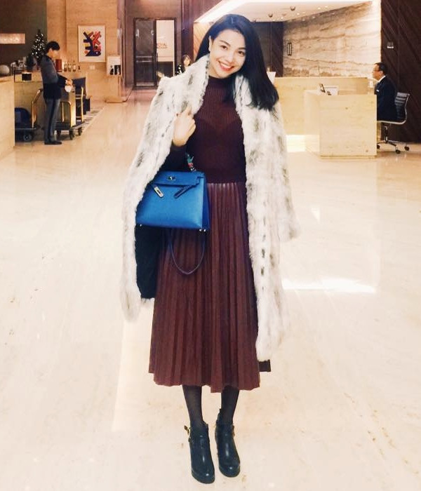 Trà Ngọc Hằng hóa quý cô sang trọng với bộ đầm liền phối vải xuyên thấu gợi cảm. Sự đối lập giữa màu của đầm và màu áo khoác tạo nét thú vị cho bộ trang phục. Điểm nhấn là túi xách màu xanh vô cùng nổi bật. 