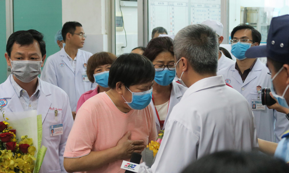 Hình ảnh bệnh nhân Li Ding (áo hồng) - một trong hai người đầu tiên nhiễm SARS-CoV-2 tại Việt Nam cúi đầu cảm ơn các bác sỹ Việt Nam trong ngày xuất viện (12/2/2020) được phóng viên Thông tấn xã Việt Nam ghi lại. (Ảnh: Đinh Hằng/TTXVN)