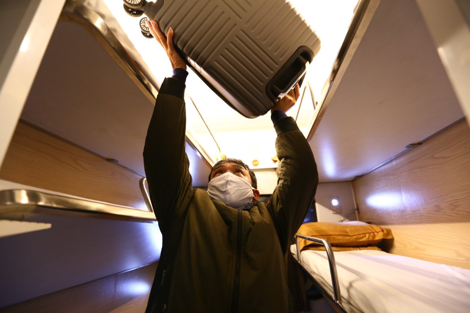 Một hành khách sắp xếp hành lý trên tàu. (Ảnh: Minh Quyết/TTXVN)