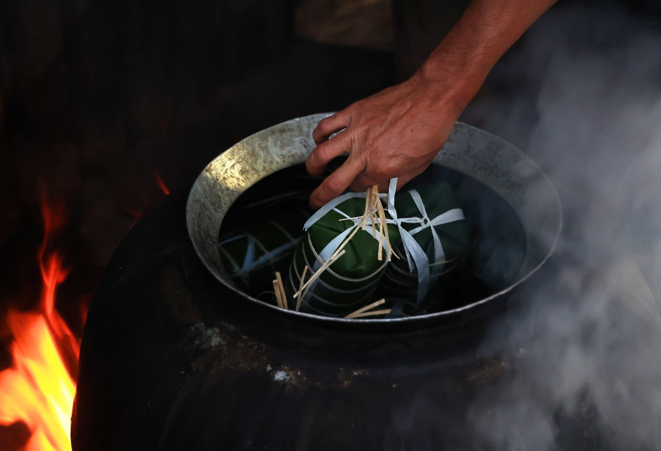 Bánh tét gói xong được nấu bằng lò củi liên tục khoảng 6-7 giờ mới chín. Từng cặp bánh tét khi được vớt ra trong thời tiết se lạnh bốc khói nghi ngút, thơm lừng thực sự là một trải nghiệm đặc biệt khi đất trời vào Xuân. (Ảnh: Hồng Đạt/TTXVN)