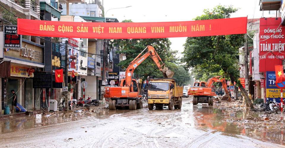 Sử dụng phương tiện máy móc để dọn dẹp đường phố khi lượng bùn đất quá nhiều. (Ảnh: Quang Cường/TTXVN)