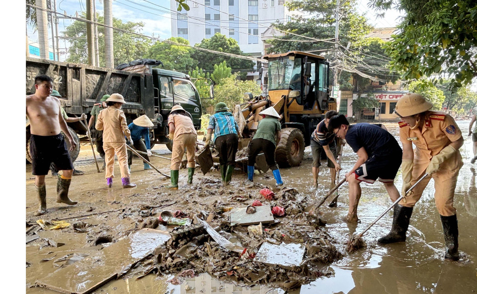 Lực lượng công an giúp người dân dọn vệ sinh đường phố. (Ảnh: Quang Cường/TTXVN)