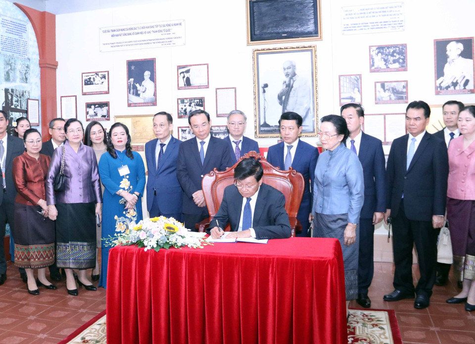 Tổng Bí thư, Chủ tịch nước Cộng hòa Dân chủ Nhân dân Lào Thongloun Sisoulith viết lưu bút cảm tưởng tại Bảo tàng Hồ Chí Minh, chi nhánh Thành phố Hồ Chí Minh. (Ảnh: Xuân Khu/TTXVN)