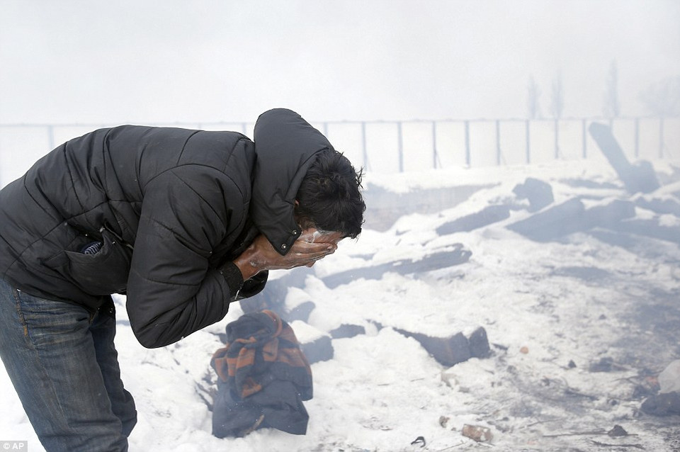 Người tị nạn này đang rửa mặt. Anh chỉ là một trong hàng trăm người đang phải ngủ trong cảnh màn trời chiếu đất ở các trại tạm ở Serbia(Nguồn: Dailymail)