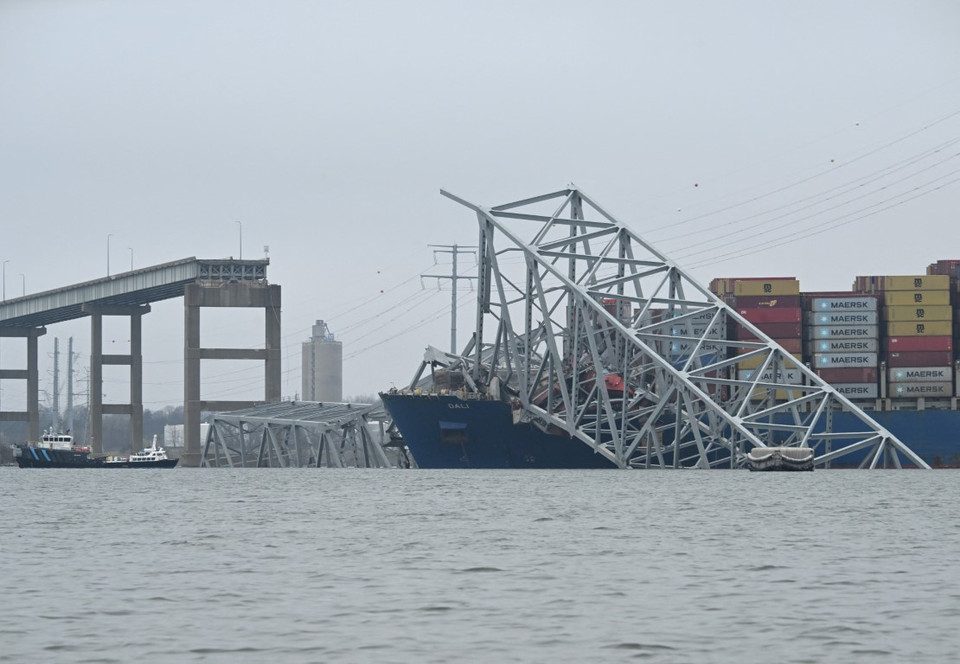 Gần như toàn bộ cây cầu thép này đã đổ sập chỉ trong vài giây, khiến nhiều người và phương tiện đang lưu thông trên cầu rơi xuống sông và chặn một trong những cảng thương mại đông đúc nhất nước Mỹ. (Ảnh: AFP/TTXVN)
