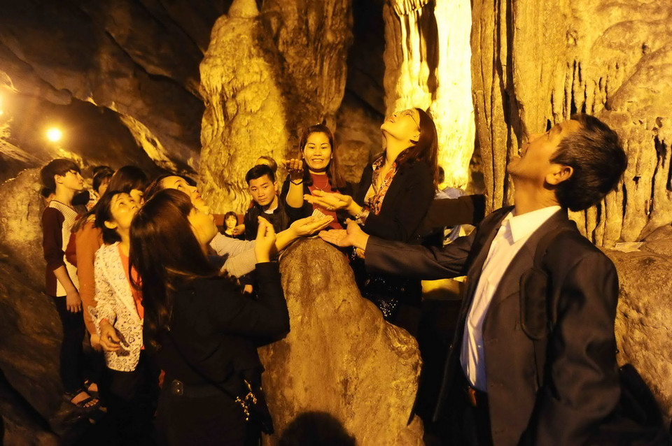 Du khách đón những giọt nhũ đá trong động Hương Tích. (Nguồn: Minh Đức/TTXVN)