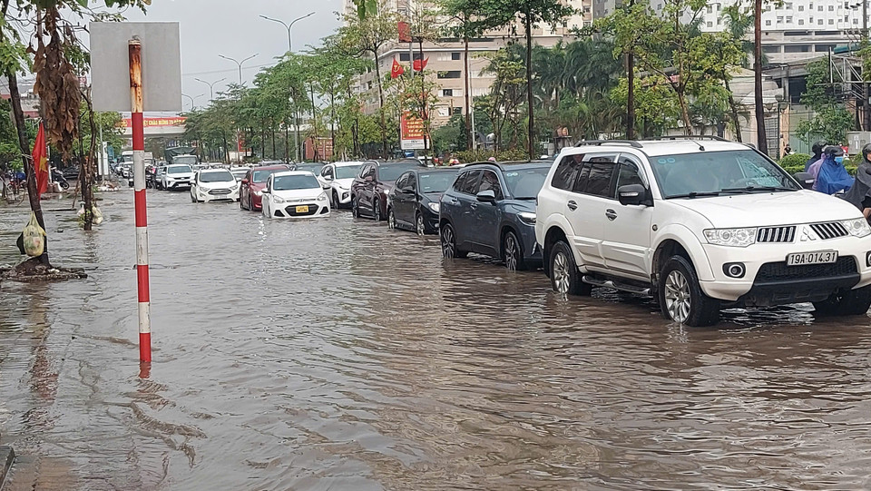 Mưa ngập khiến phương tiện di chuyển khó khăn trên Quốc lộ 32 đoạn qua Lai Xá, Kim Chung, Hoài Đức (chụp lúc 7h sáng). (Ảnh: Văn Điệp/TTXVN)