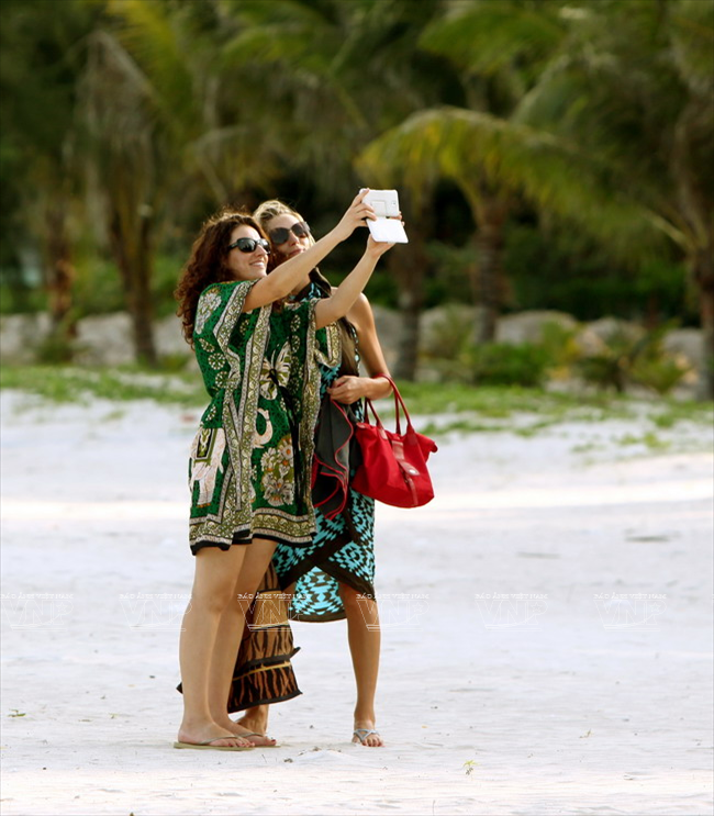 Du khách nước ngoài chụp ảnh lưu niệm trên bãi biển Côn Đảo. (Ảnh: Lê Minh)