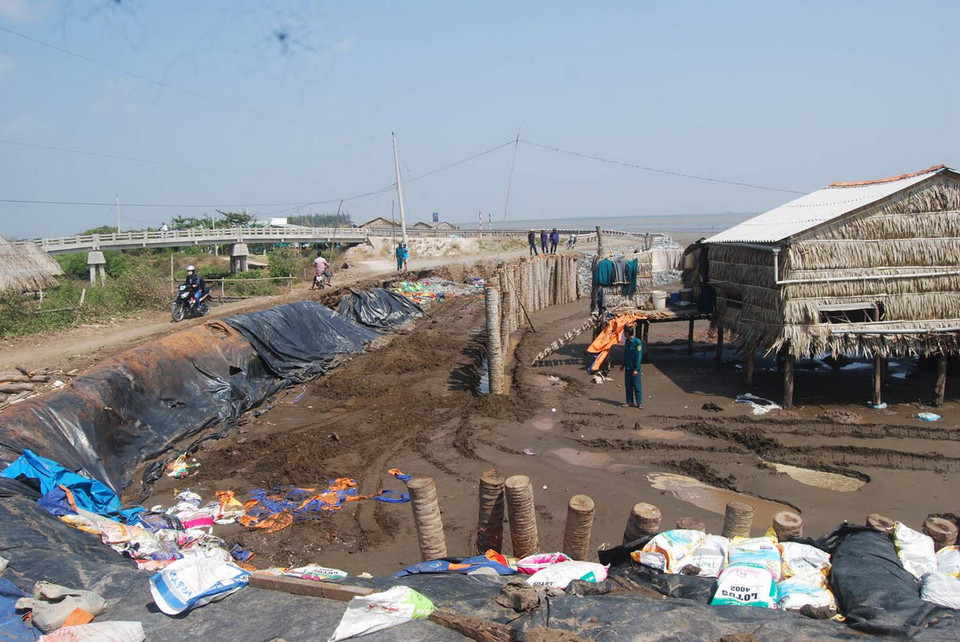 Sạt lở ăn sâu vào đường và mố cầu ở cồn. (Ảnh: Văn Trí/TTXVN)