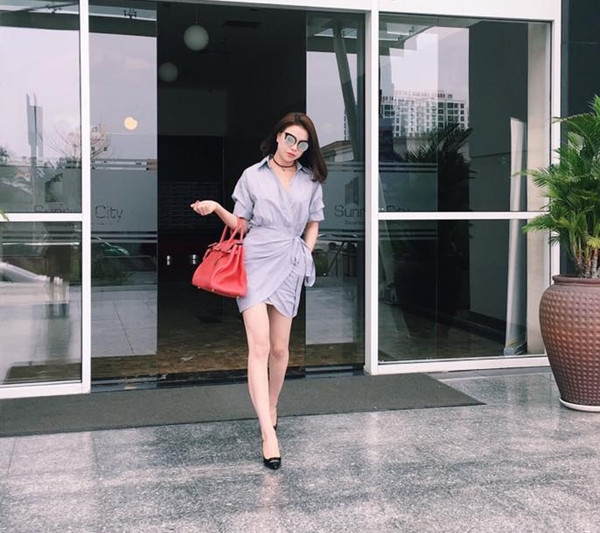 Trà Ngọc Hằng chào ngày mới với đầm quấn màu xanh phấn, phối cùng giày cao gót đen và điểm trang bằng túi xách gam màu rực rỡ