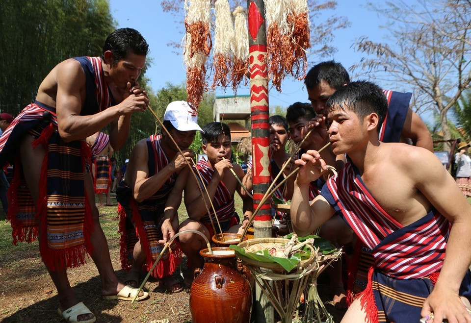 Dân làng uống rượu cần mừng lễ bắc máng nước. (Ảnh: Dương Giang/TTXVN)