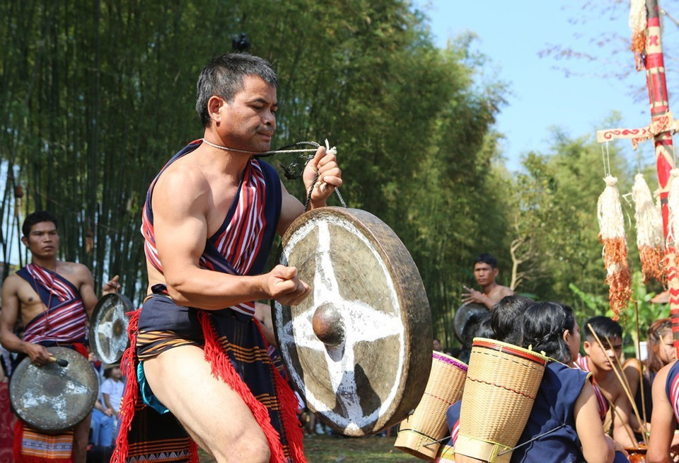Trai tráng trong làng đánh cồng chiêng mừng lễ bắc máng nước. (Ảnh: Dương Giang/TTXVN)