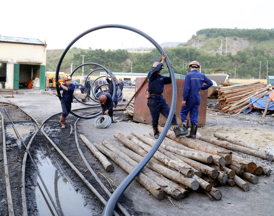 Đưa đường ống nước vào trong hầm lò. (Ảnh: Nguyễn Hoàng/Vietnam+)