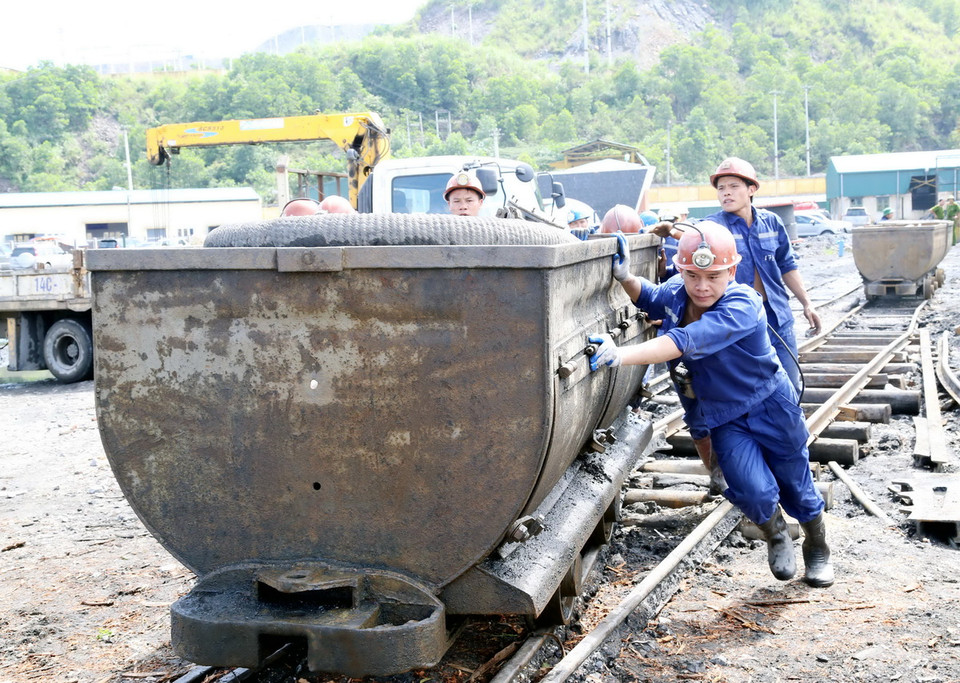 Các công nhân cứu hộ đang dùng xe goong vận chuyển thiết bị vào hầm phục vụ công tác tìm kiếm cứu nạn. (Ảnh: Nguyễn Hoàng/Vietnam+)