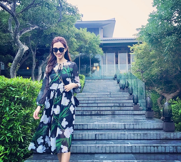 Đầm in hoa cũng là lựa chọn của Hoa hậu Đặng Thu Thảo trong những ngày thư giãn cuối tuần. Người đẹp diện thiết kế màu tối phối vải sheer tinh tế, kết hợp túi đeo nhỏ càng làm tăng vẻ nữ tính.