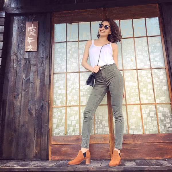 Nhờ phép cộng áo thun trắng, quần jeans cạp cao và bốt cao gót, Trà Ngọc Hằng đã phô diễn hoàn hảo đường cong gợi cảm và 'tỏa sáng' với vẻ rạng rỡ, lôi cuốn.