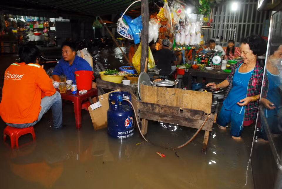 Quán ốc của bà Huỳnh Thị Mười (60 tuổi, xã Phước Kiểng, huyện Nhà Bè) chìm trong biển nước. (Ảnh: Mạnh Linh/TTXVN) 