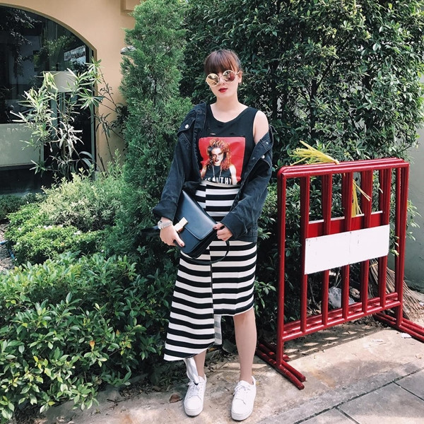 Trưng dụng áo tank in hình và chân váy kẻ ngang bất đối xứng, Yến Nhi biến tấu ngẫu hứng set đồ dạo phố khi thêm denim khoác ngoài, giày thể thao khỏe khoắn và kính mắt tráng gương thời thượng.