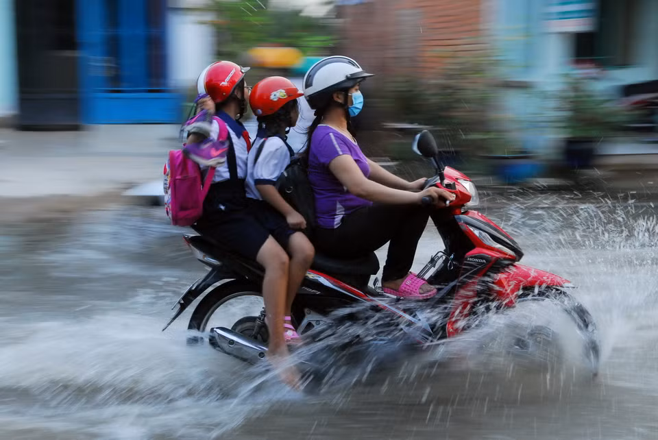  Người dân lưu thông khó khăn trên đường Lê Văn Lương (huyện Nhà Bè). (Ảnh: Mạnh Linh/TTXVN) 