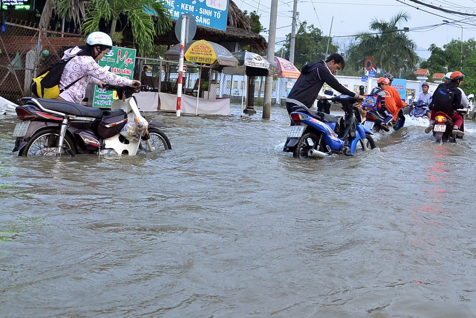 Người dân lưu thông khó khăn trên đường Lê Văn Lương (huyện Nhà Bè). (Ảnh: Mạnh Linh/TTXVN) 