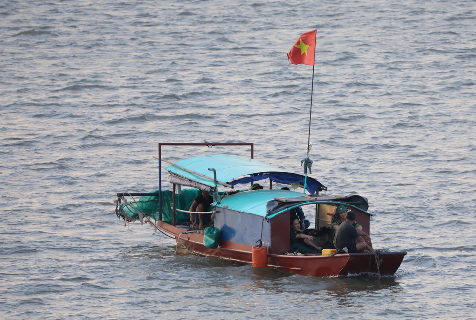 Lực lượng chức năng lai dắt quả bom trên sông Hồng, đưa về nơi xử lý an toàn. (Ảnh: Thành Đạt/TTXVN)