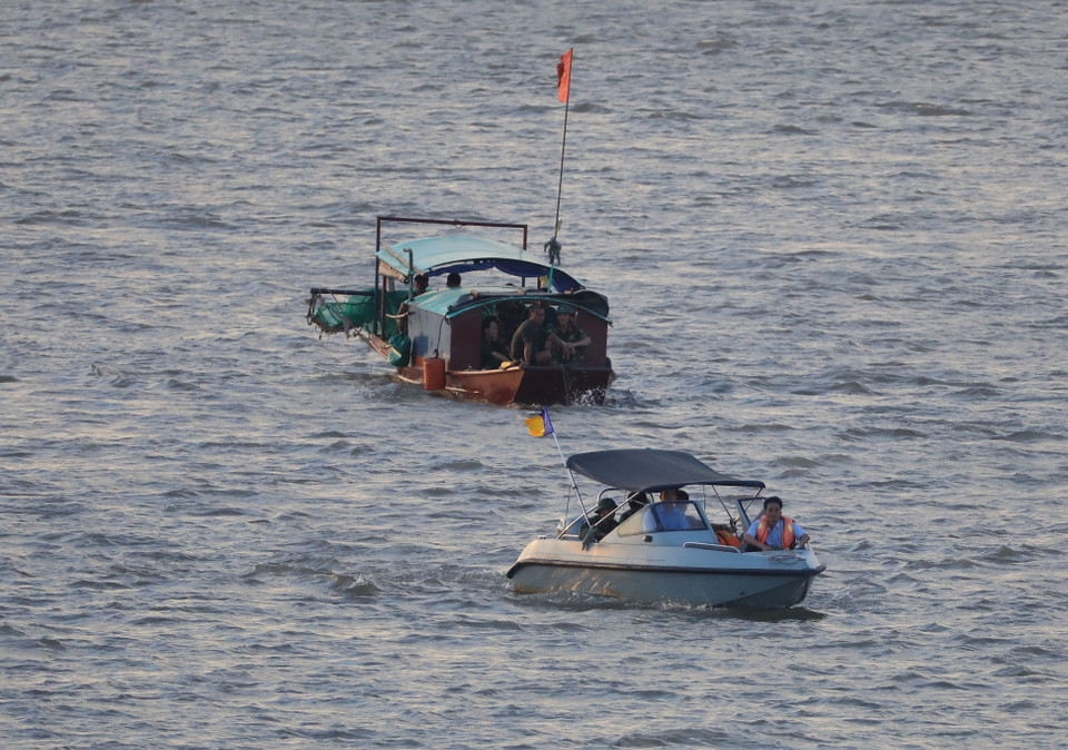 Lực lượng chức năng lai dắt quả bom trên sông Hồng, đưa về nơi xử lý an toàn. (Ảnh: Thành Đạt/TTXVN)