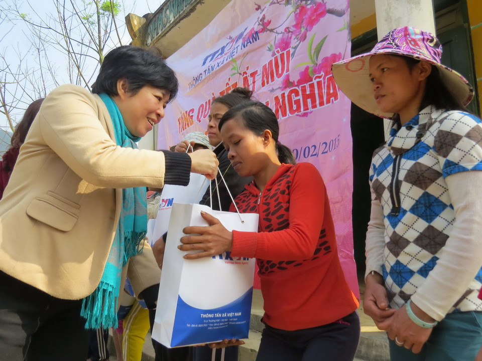 Bà Nguyễn Thị Thúy, Phó Chủ tịch Công đoàn TTXVN trao tặng quà tết cho đồng bào Rục ở xã Thượng Hóa, huyện Minh Hóa. (Ảnh: Mạnh Thành/TTXVN)