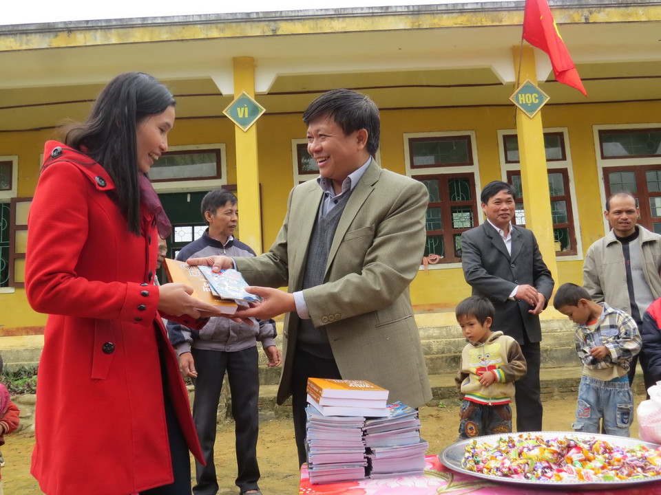 Phó Tổng giám đốc Đinh Đăng Quang trao tặng quà cho học sinh, giáo viên ở xã Ngân Thủy. (Ảnh: Mạnh Thành/TTXVN)