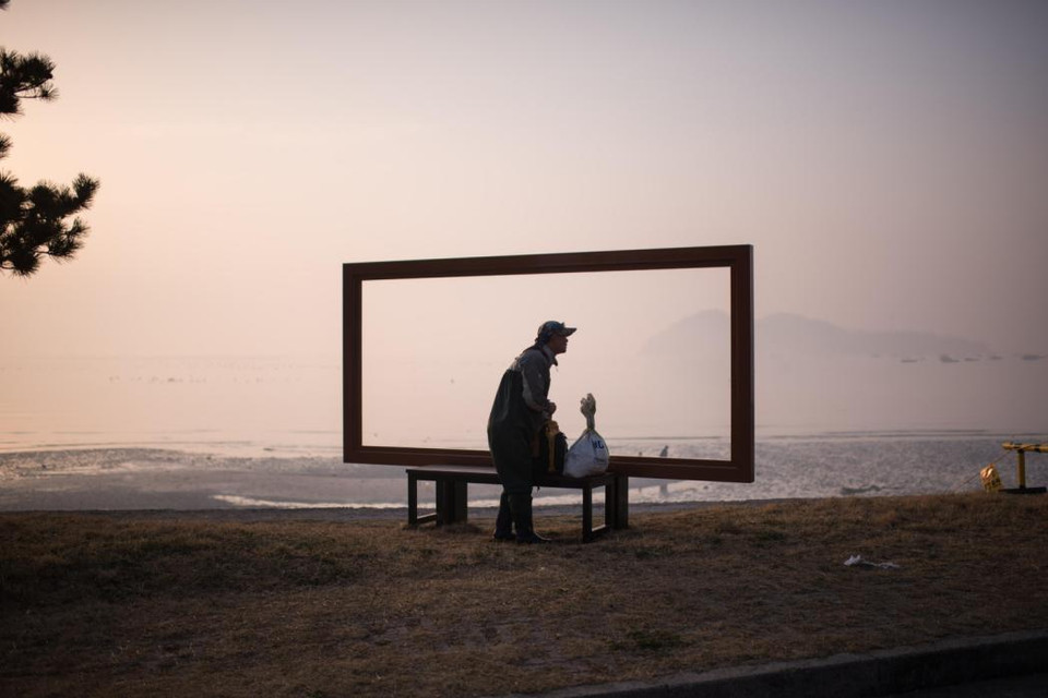 Bức ảnh được chụp vào ngày 21 tháng 3 năm 2015, một ngư dân lưu lại khoảnh khắc sau khi thủy triều xuống để lộ con đường đất đá rộng lớn nối liền hai hòn đảo Jindo và Modo ở Hàn Quốc. (Nguồn: AFP)