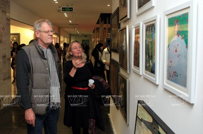  Du khách nước ngoài thích thú khi tham quan chợ tranh. (Ảnh: Trần Thanh Giang/Báo ảnh Việt Nam)
