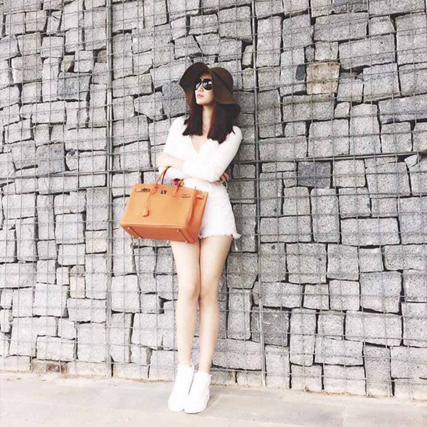 Khánh My diện 'cây' trắng xuống phố tuần qua. Điểm nhấn trong trang phục của người đẹp chính là chiếc túi xách đắt giá có tông màu vàng cam nổi trội.
