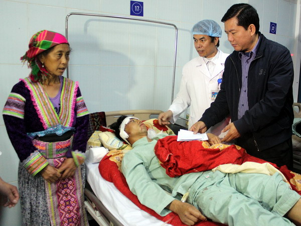 Bộ trưởng Đinh La Thăng thăm, động viên tặng quà các nạn nhân tại Bệnh viện Đa khoa tỉnh Lai Châu. (Ảnh: Hải Sơn/Vietnam+)