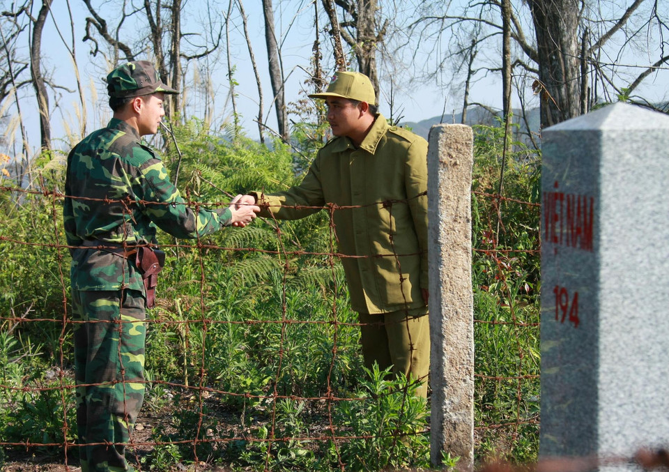  Lực lượng biên phòng Việt Nam và Lào bắt tay tại cột mốc 194, Đồn Biên phòng Mường Lạn. (Ảnh: Nguyễn Chiến/TTXVN)