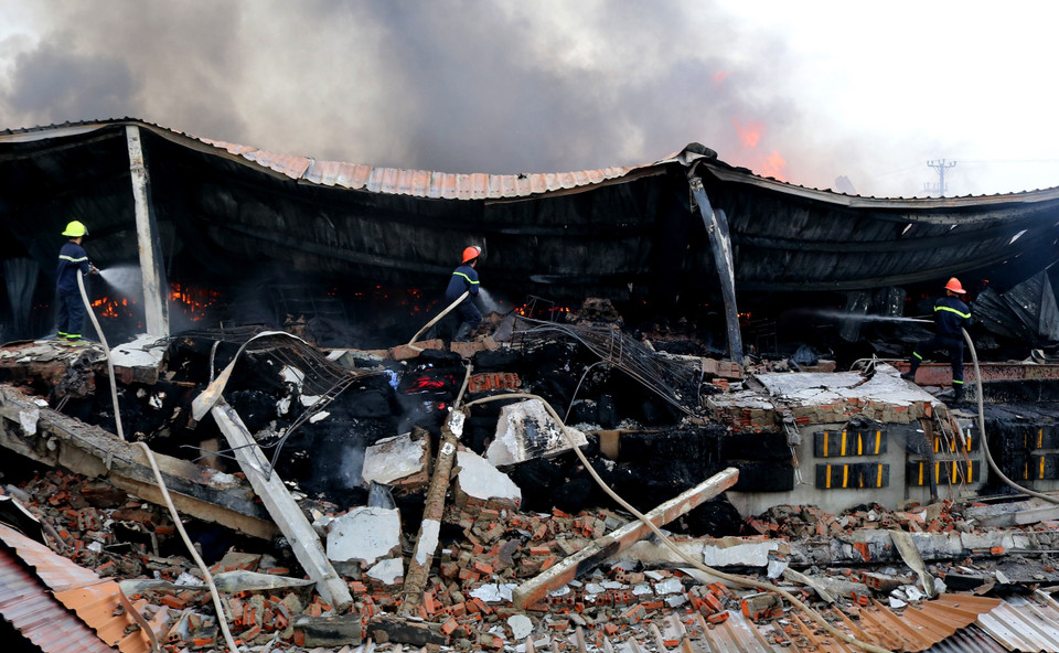 Lực lượng phòng cháy chữa cháy tích cực dập lửa tại khu vực cháy. (Ảnh: Trung Kiên/TTXVN)