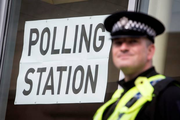 Một nhân viên cảnh sát đứng bên ngoại điểm bỏ phiếu ở thư viện Birstall, West Yorkshiew, gần nơi nghị sỹ Jo Cox bị ám sát. (Nguồn: belfasttelegraph.co.uk) 