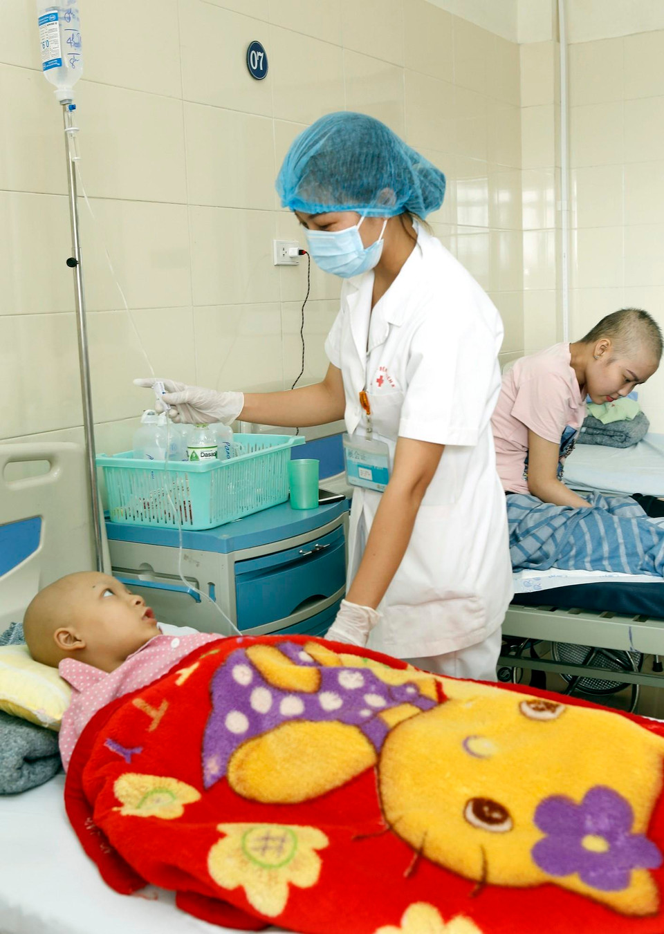 Bác sỹ Bệnh viện K chăm sóc điều trị cho bệnh nhi ung thư. (Ảnh: Dương Ngọc/TTXVN)