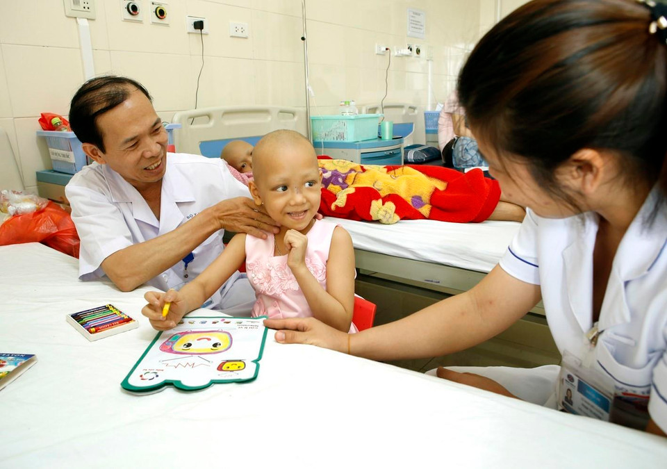 Bác sỹ bệnh viện K chăm sóc điều trị cho bệnh nhi ung thư. (Ảnh: Dương Ngọc/TTXVN)