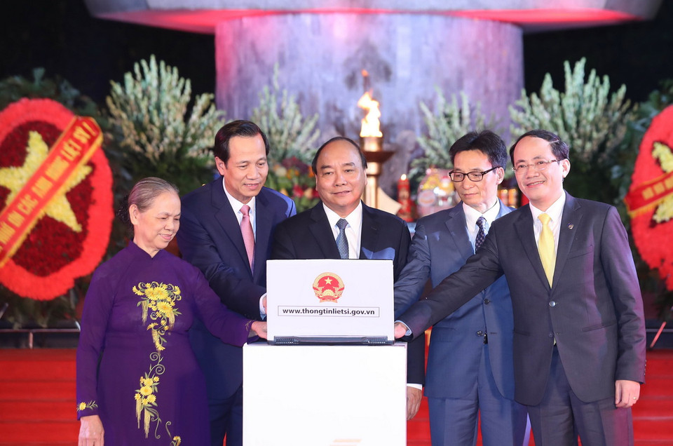 Thủ tướng Nguyễn Xuân Phúc và các đại biểu ấn nút khai trương cổng thông tin điện tử về liệt sỹ, mộ liệt sỹ, nghĩa trang liệt sỹ theo địa chỉ thongtinlietsi.gov.vn. (Ảnh: Thống Nhất/TTXVN)