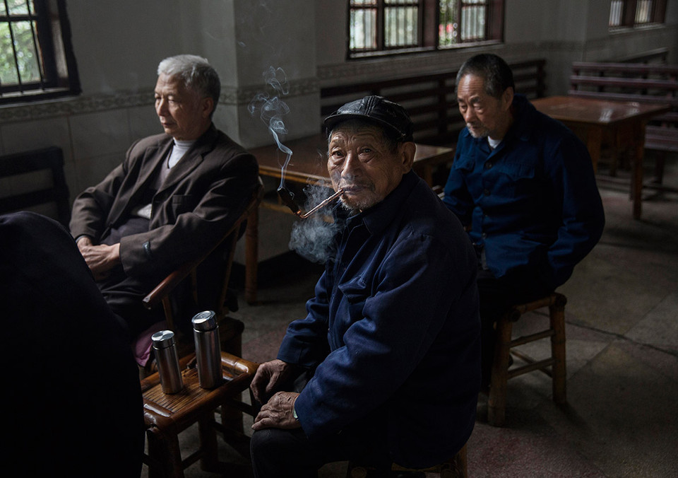 Ông già đang hút thuốc gần đường ray ở thị trấn Bagou. (Ảnh: Kevin Frayer/Ibtimes)