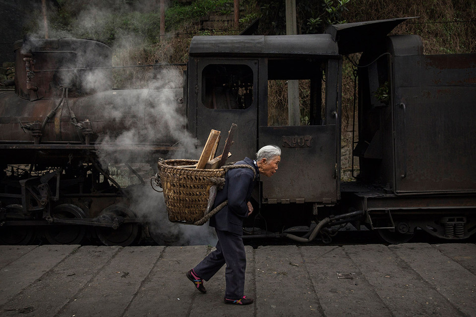 Bà già các củi qua nhà ga. (Ảnh: Kevin Frayer/Ibtimes)