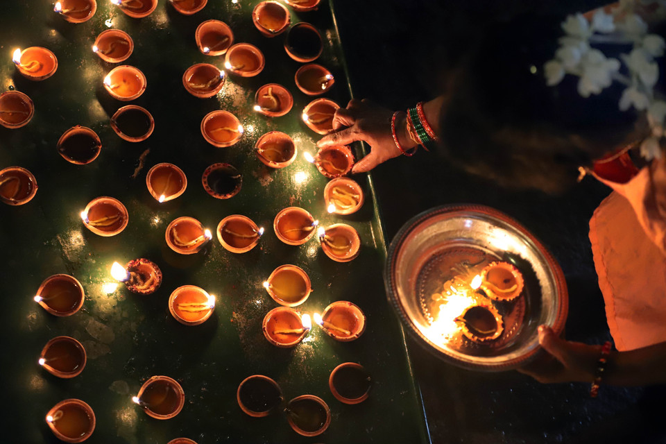 Một tín đồ Hindu thắp đèn dầu trong lễ hội Diwali ở Colombo (Sri Lanka) đêm 31/10/2024. (Ảnh: THX/TTXVN)