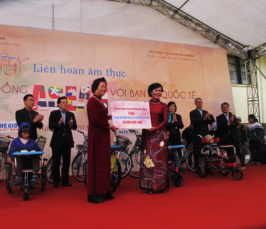 Bà Mai Thị Hạnh - Phu nhân Chủ tịch nước Trương Tấn Sang trao quà từ thiện cho đại diện của “Hội Bảo trợ Người tàn tật và trẻ em mồ côi Việt Nam” (Ảnh: Tiến Đạt/Vietnam+)