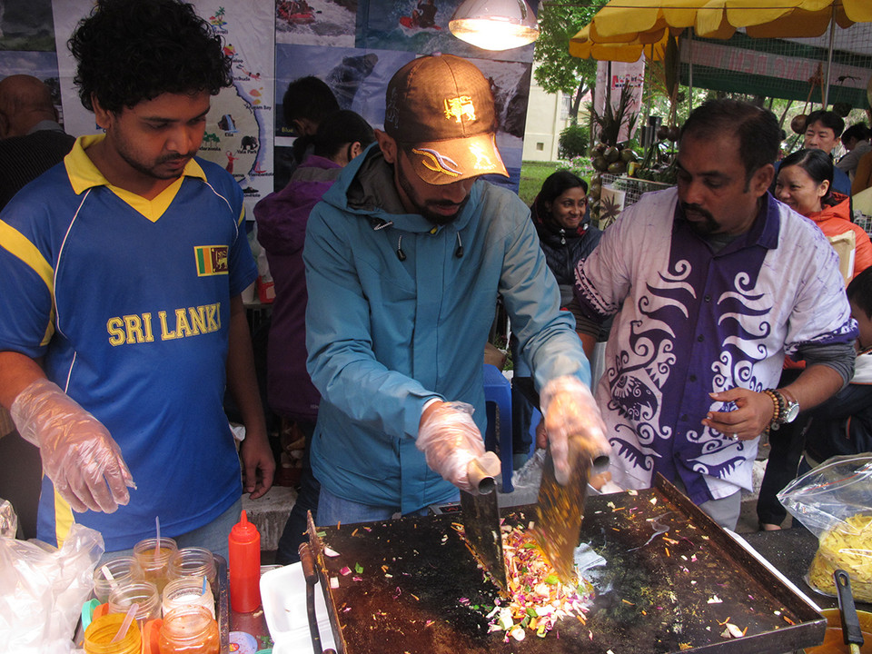 Các đầu bếp đến từ Sri Lanka đang chế biến các món ăn phục vụ khách tham quan. (Ảnh: Tiến Đạt/Vietnam+)