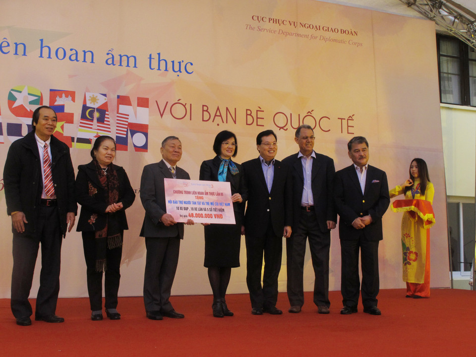 Đại sứ Nguyễn Nguyệt Nga, Phu nhân Phó Thủ tướng, Bộ trưởng Bộ Ngoại giao Phạm Bình Minh, Trưởng đoàn Ngoại giao, Đại sứ Malaysia và Trưởng ban tổ chức trao quà từ thiện bằng hiện vật cho các cá nhân có hoàn cảnh khó khăn. (Ảnh: Tiến Đạt/Vietnam+)