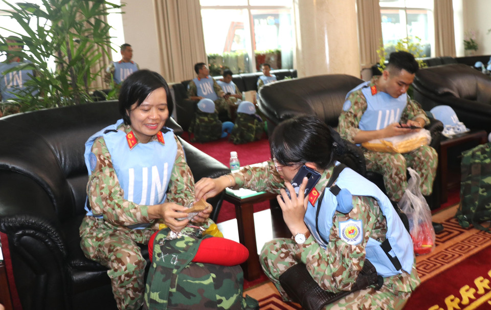 Thiếu tá Bùi Thị Xoa (bên trái), "chị cả" của nhóm 10 nữ cán bộ, nhân viên Bệnh viện Dã chiến cấp 2 số 1, chăm sóc Thiếu úy Huỳnh Cẩm Thơ trước lúc lên máy bay sang Nam Sudan. (Ảnh: Xuân Khu/TTXVN)