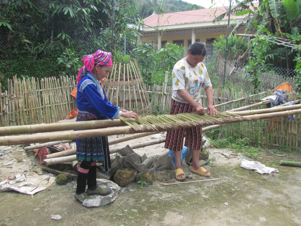 Bà Thào Thị Nhừ, dân tộc Mông, 90 tuổi ở bản Dền Thàng A, xã Dào San, huyện Phong Thổ (Lai Châu) dạy cháu dâu cách phơi hương không bị dính vào nhau. (Ảnh: Việt Hoàng/TTXVN)