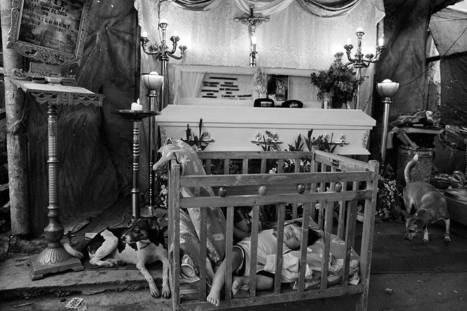 Em bé Aviel (1 tuổi) đang ngủ tại lễ tang của bố mình là Christian Nufable (34 tuổi). Anh đã bị các tay súng giấu danh bắn chết, bỏ lại vợ và 2 con nhỏ. (Nguồn: Time)