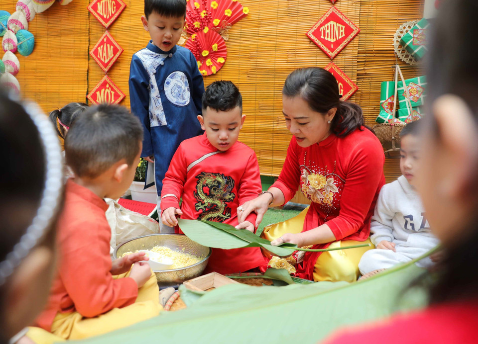 Cùng cô trải nghiệm gói bánh chưng Tết. (Ảnh: Thanh Tùng/TTXVN)