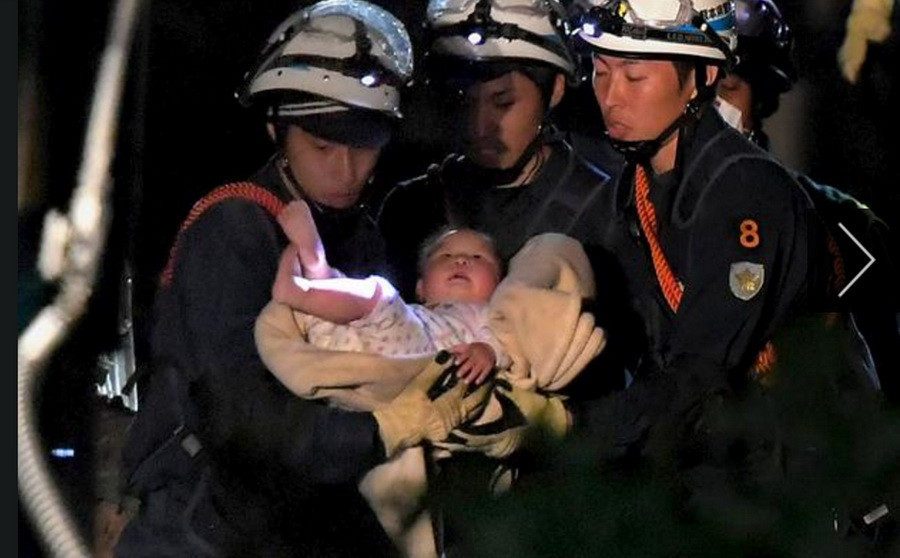 Nhân viên cứu hộ cứu sống một em bé 8 tháng tuổi bị mắc kẹt trong đống đổ nát do động đất tại thị trấn Mashiki, tỉnh Kumamoto ngày 15/4. (Nguồn: Reuters/TTXVN)