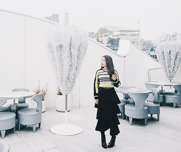 Tóc Tiên biến tấu mới lạ công thức mix đầm đen và áo khoác denim bụi phủi bằng chiếc khăn cổ quàng hờ và túi xách mini đính móc lông thời thượng.